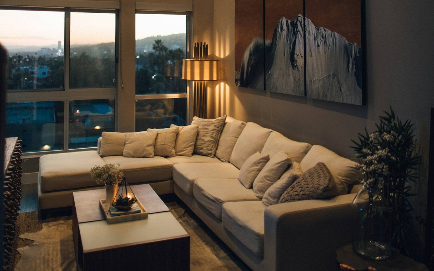 Sunlit living room with a sectional and floor lamp